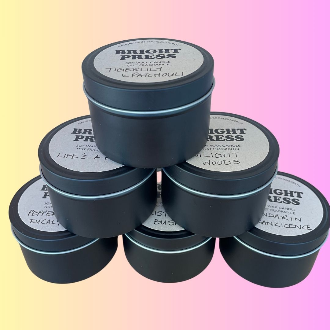 A 6-tin pyramid of Test Fragrance Soy Wax Candles