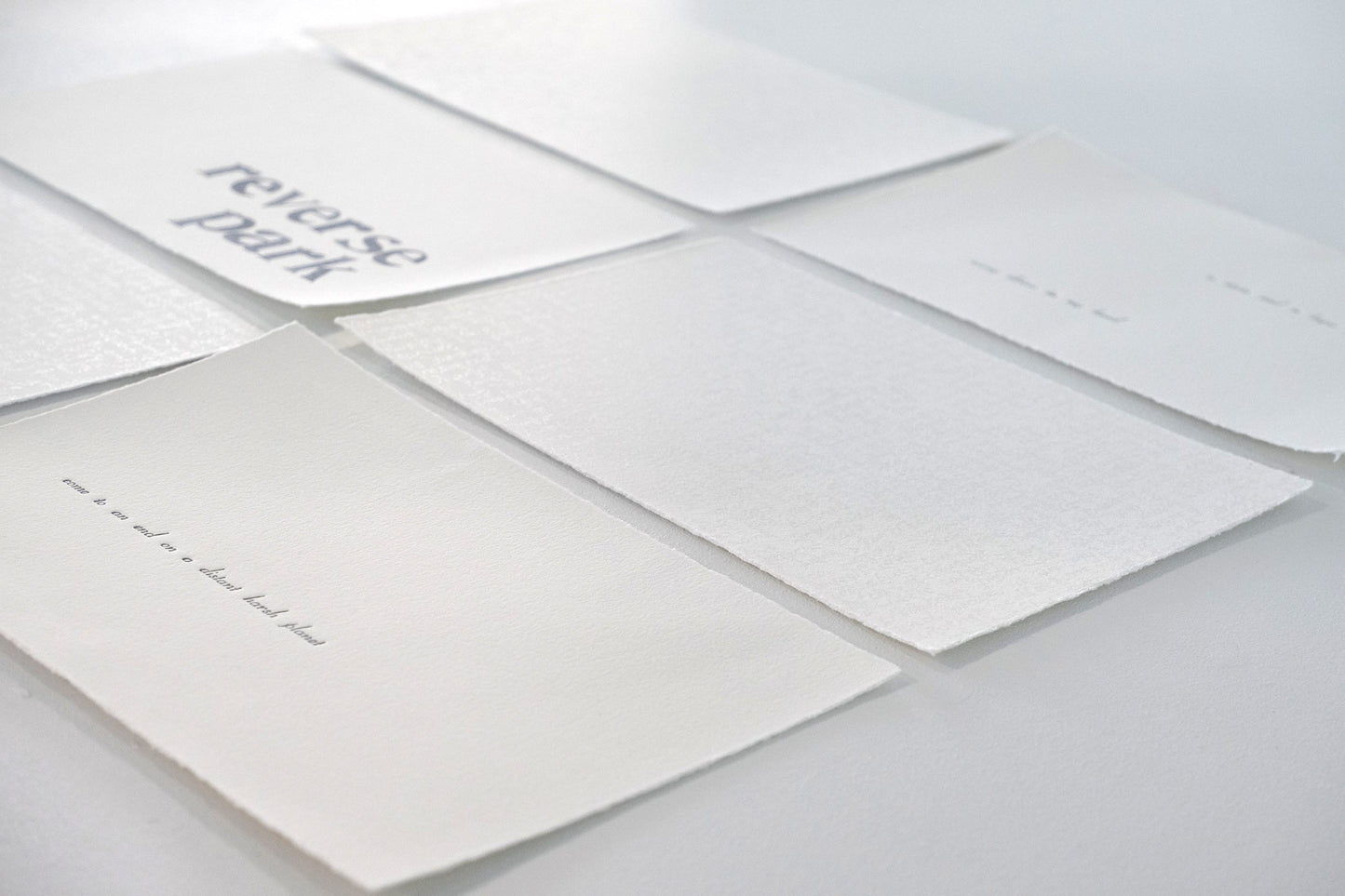 Vanessa Wallace's work - letterpress prints on white paper with blue-grey text on a white background