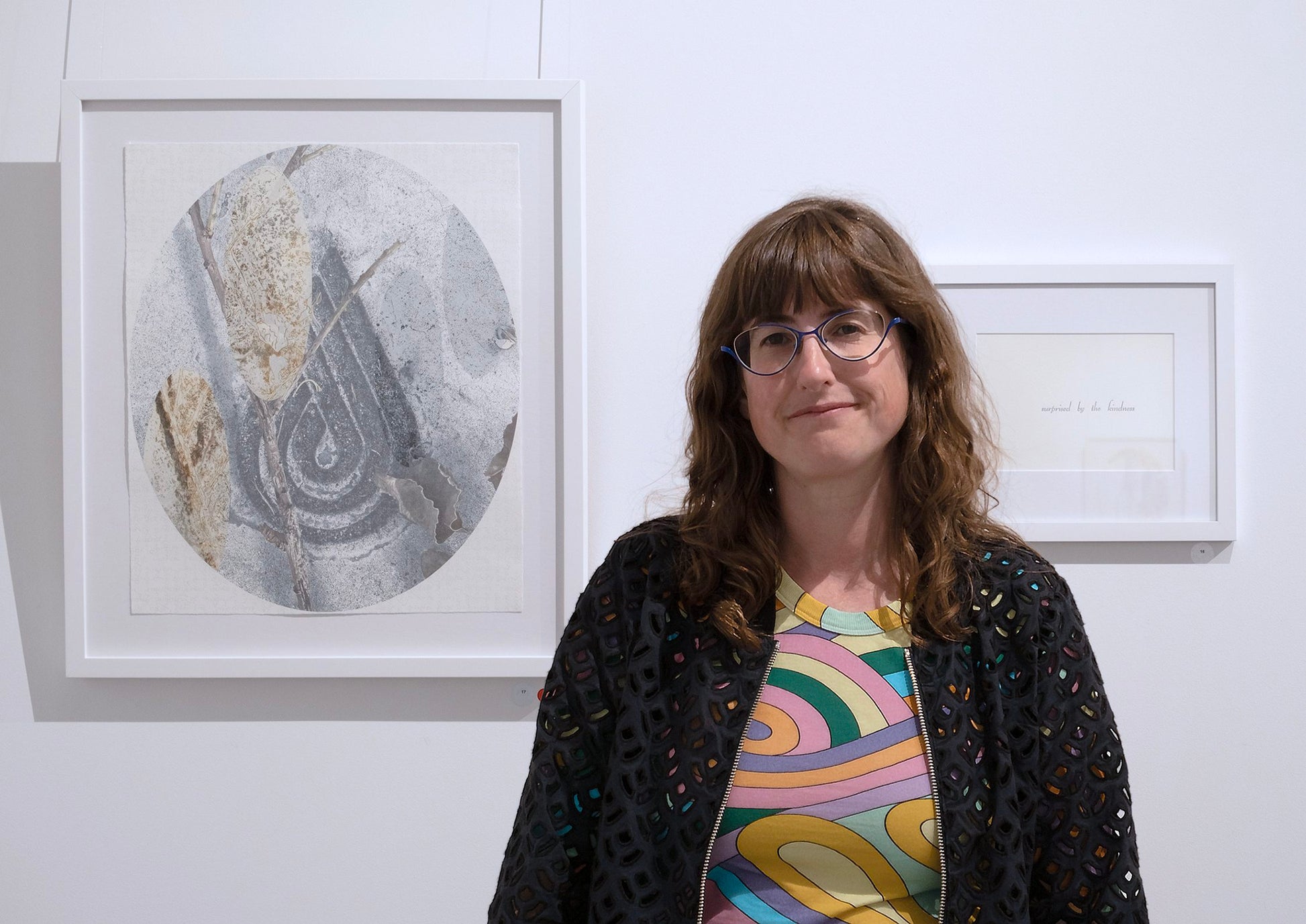 Vanessa Wallace standing in front of framed artwork on a wall