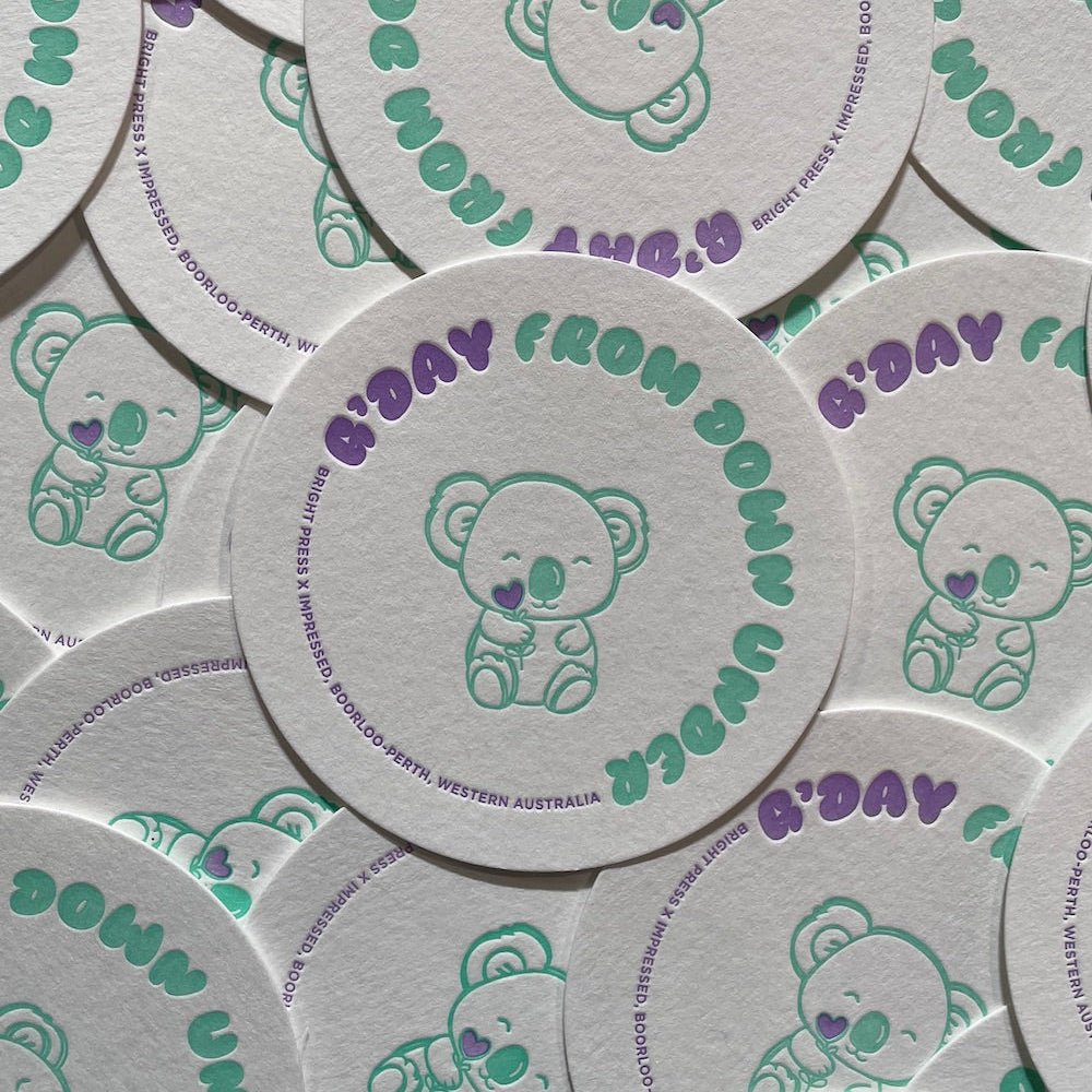 Circular coasters with a koala illustration and text on a white background