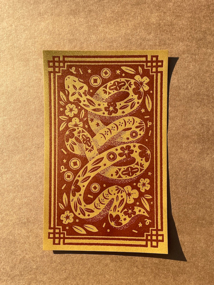 Flat lay of the Year of the snake print on a brown background