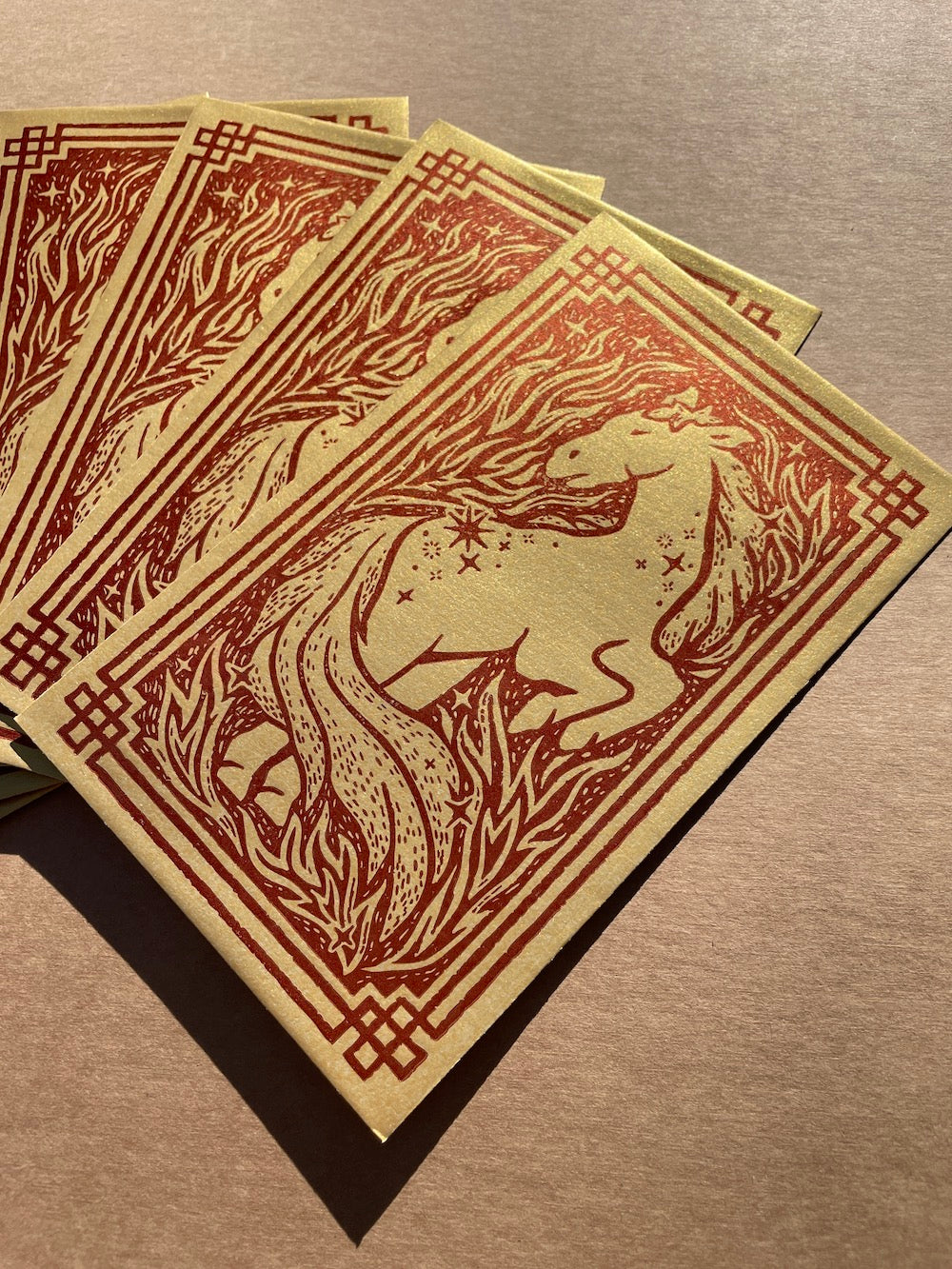 Close up view of a set of envelopes with a horse design on a brown surface