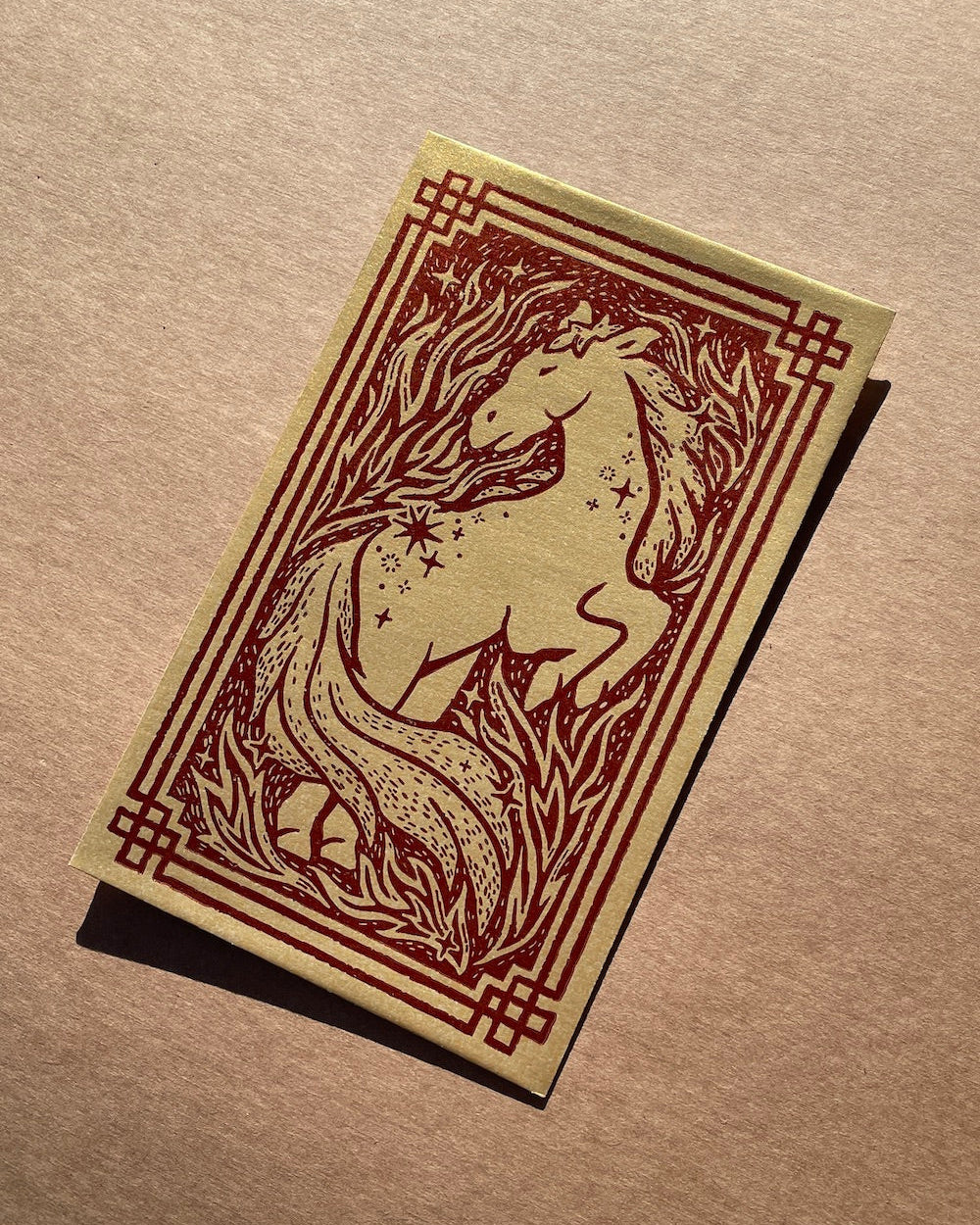 Decorative envelope with a horse design on a brown background