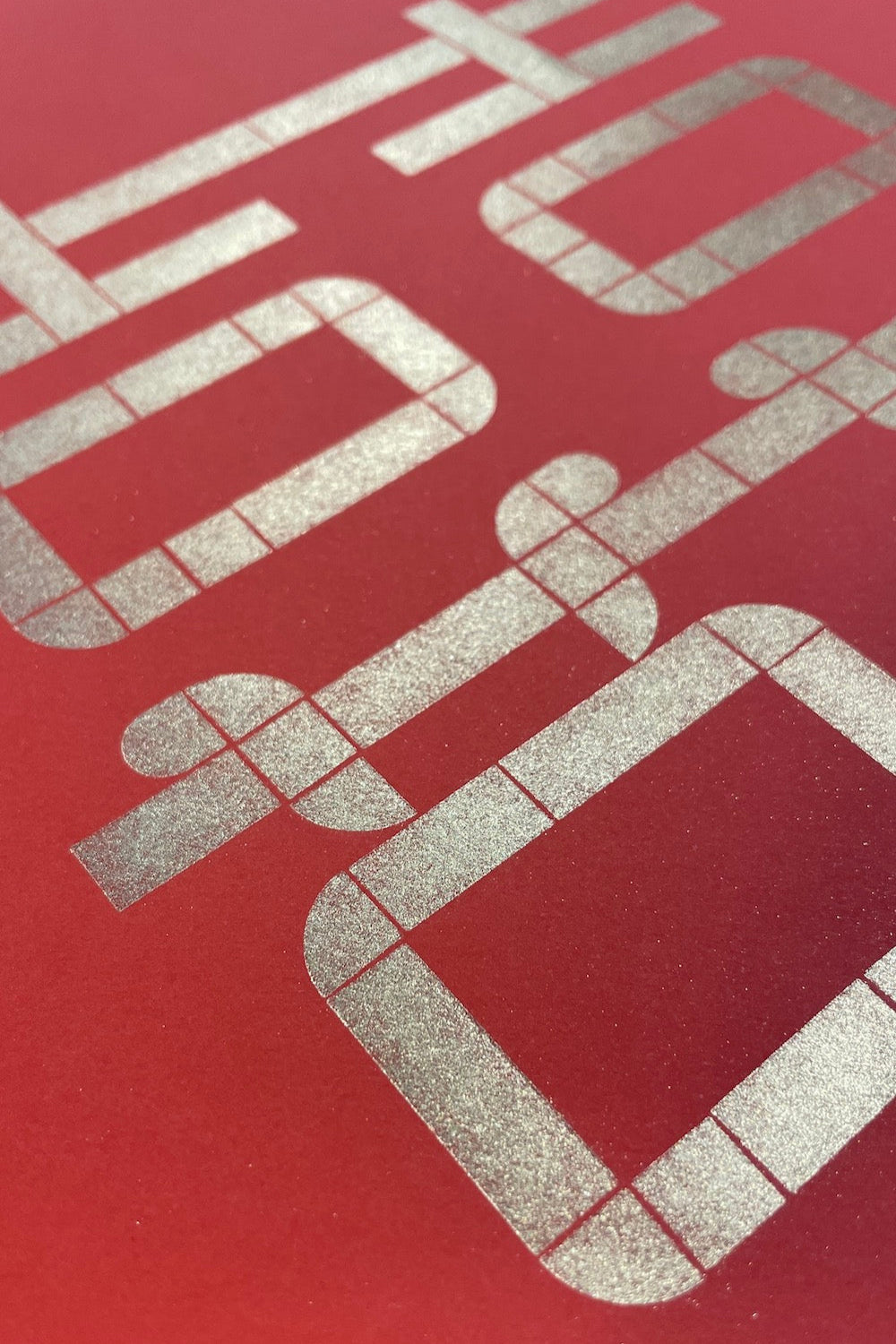 Close up of the character "Double Happiness". It is shiny and gold from the gold dust applied. The paper is red in colour.